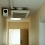 Caisson de VMC fixé au plafond d'un couloir de maison